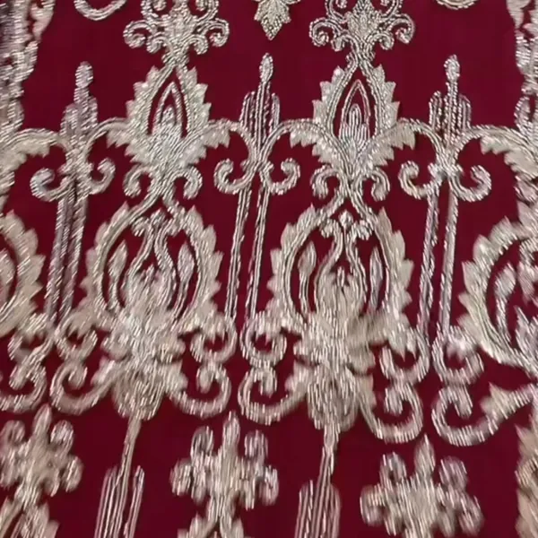 Close-up of maroon fabric with cream and silver embroidery